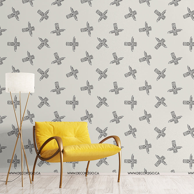 A minimalist living room featuring a bright yellow, fabric single-seater sofa and a tall, slender floor lamp with a white shade. The background shows soft gray Decor2Go Totem Pole Wallpaper Mural.