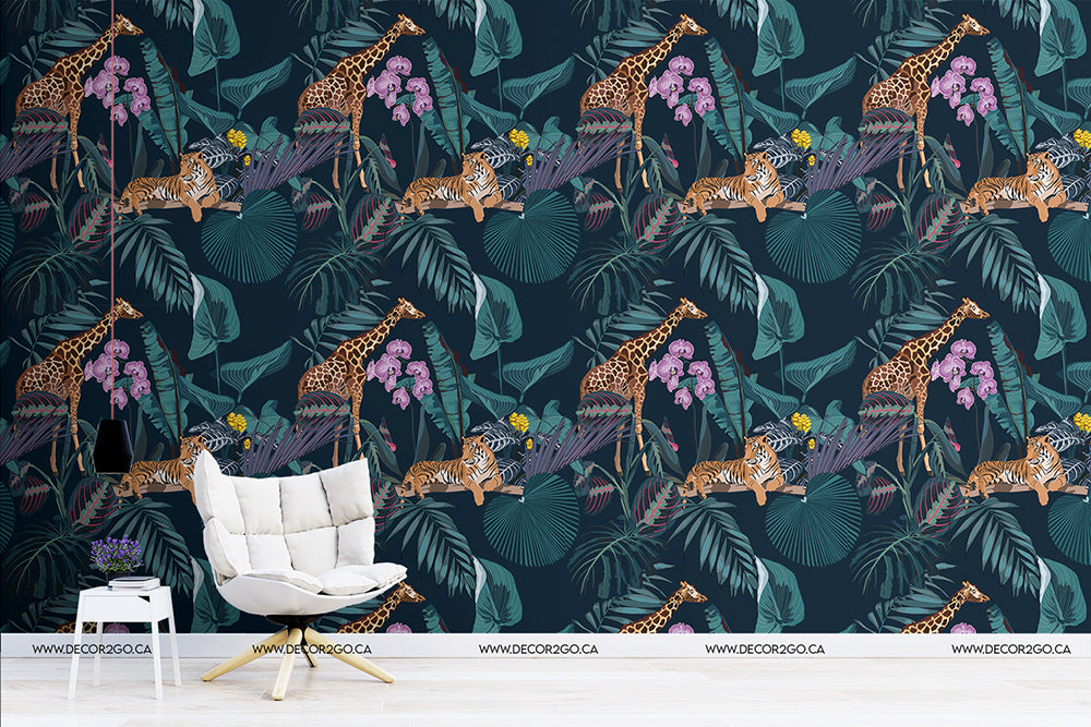 A stylish room with a wall covered in vibrant Decor2Go Wallpaper Mural featuring leopards, parrots, and large green palm leaves. A white modern chair and a small white table with books are in front