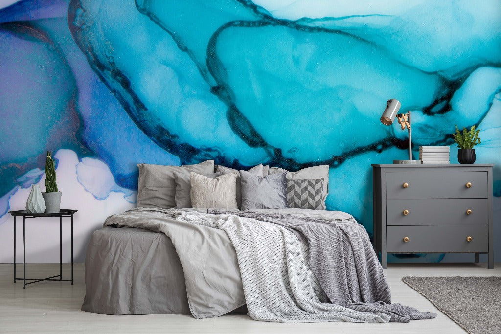 Bedroom - A stylish bedroom featuring an oversized Decor2Go Turquoise Ink Wallpaper Mural behind a bed dressed in gray linen. Beside the bed is a dark gray dresser and a small table with a plant and lamp.
