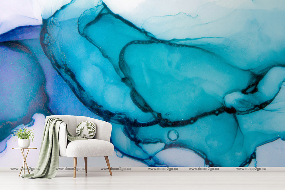 Minimalist styled room featuring a modern armchair with a white throw and cushion beside a small green plant on a white stand. Behind, a large abstract Turquoise Ink Wallpaper Mural from Decor2Go Wallpaper Mural adorns the wall.