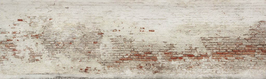 Aged white wall with Decor2Go Wallpaper Mural peeling off, revealing underlying red brick in various patches, showing signs of wear and decay.