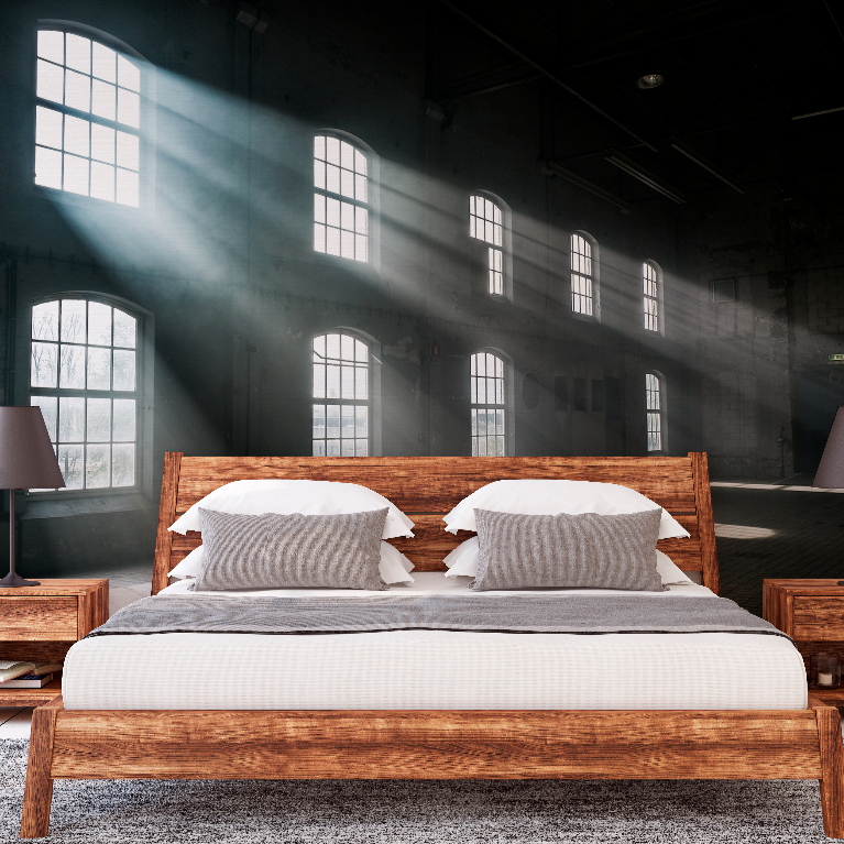 A modern wooden double bed with striped pillows in a spacious, industrial-style loft room, with sunlight streaming through large arched windows, casting interior shadows across the dark airy space. The room is beautifully adorned with the Versailles Wallpaper Mural from Decor2Go Wallpaper Mural.
