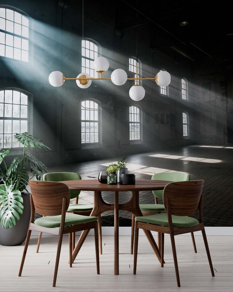 A stylish modern dining area featuring a round table surrounded by wooden chairs, set in a spacious room with large windows, hanging spherical lamps, and natural sunlight casting dramatic light and shadows adorned with Decor2Go Wallpaper Mural's Versailles Wallpaper Mural.