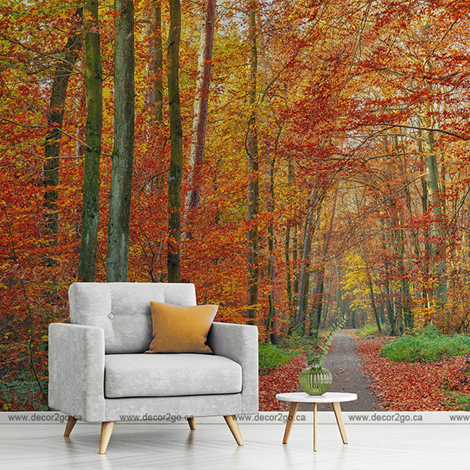 A modern grey armchair with a yellow cushion and a small round table placed on a pathway in the Decor2Go Wallpaper Mural with red, orange, and yellow leaves.