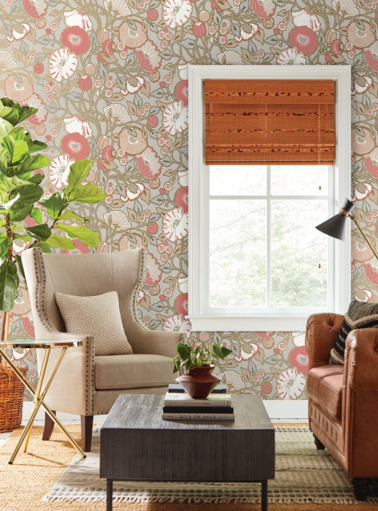 Grey pink floral wallpaper on the wall, beautiful beige chair and brown leather sofa