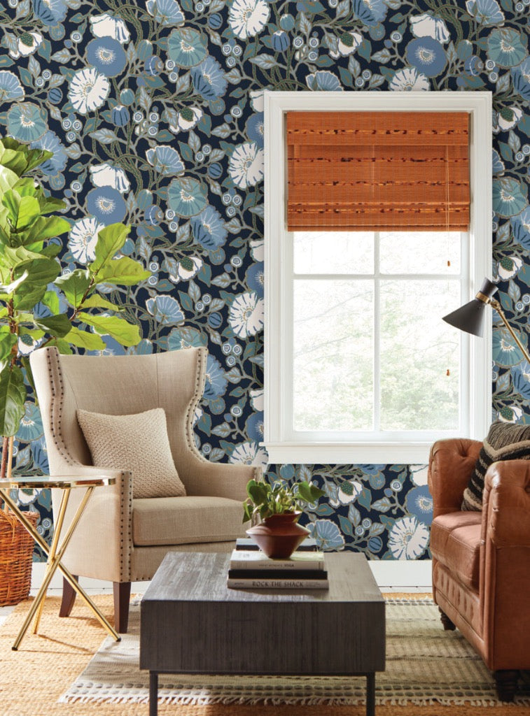 black blue floral wallpaper on the wall, beautiful beige chair and brown leather sofa