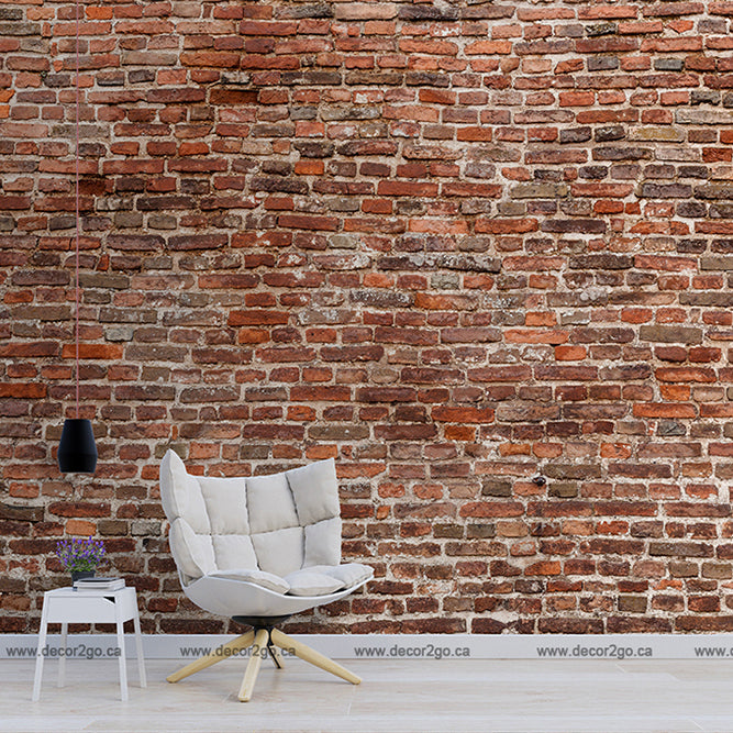 A contemporary room featuring a large Washed Classic Brick Wall Wallpaper Mural from Decor2Go Wallpaper Mural, with a stylish single white chair, a small round side table, and a hanging black pendant lamp.