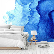 Bedroom - A contemporary bedroom featuring a bed with white and gray bedding, a small wooden side table with a lamp and clock, and a striking deep blue Decor2Go Wallpaper Mural.