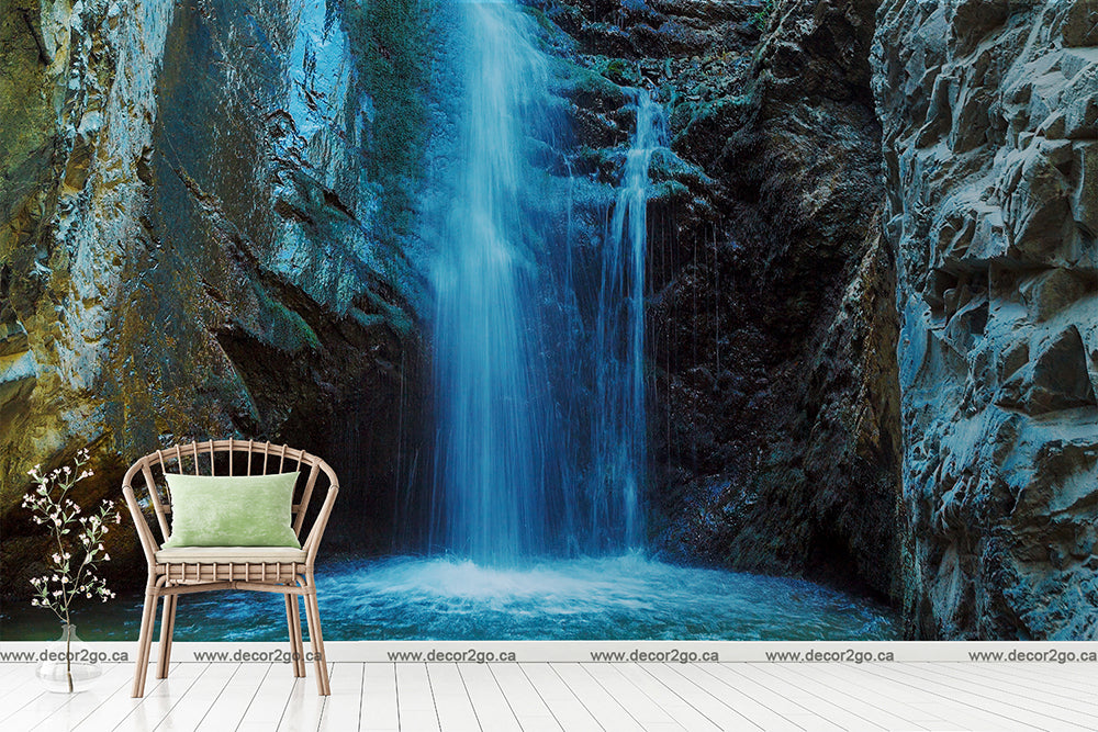 A serene mural of Decor2Go Wallpaper Mural's Waterfall Cave Wallpaper Mural with a plush wicker chair and a vase of flowers in the foreground, creating a relaxing indoor atmosphere with a natural scenic backdrop.
