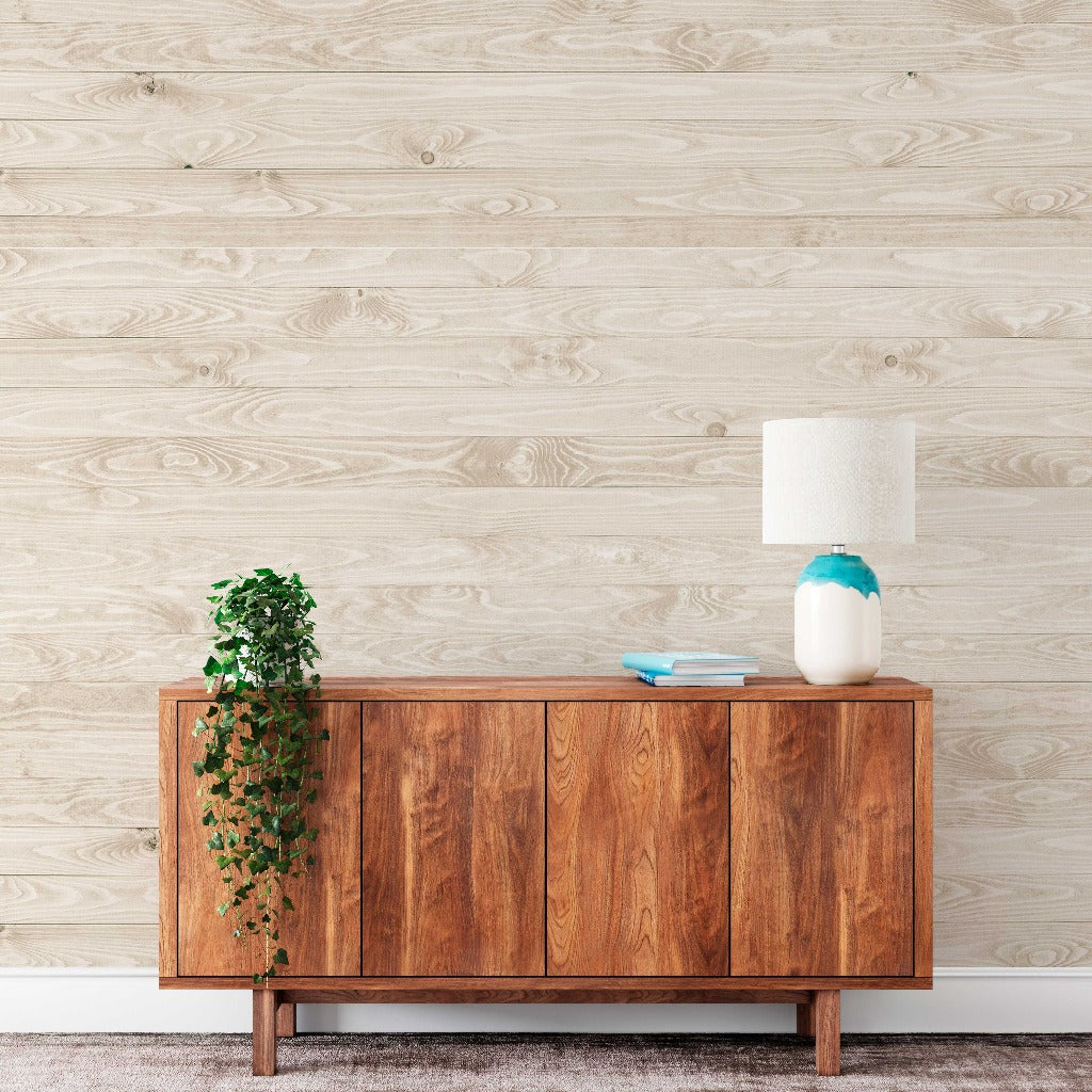 Living Room - A modern living room featuring a wooden sideboard against a Decor2Go Wallpaper Mural, adorned with a cascading potted plant, two blue books, and a white-and-blue ceramic lamp.