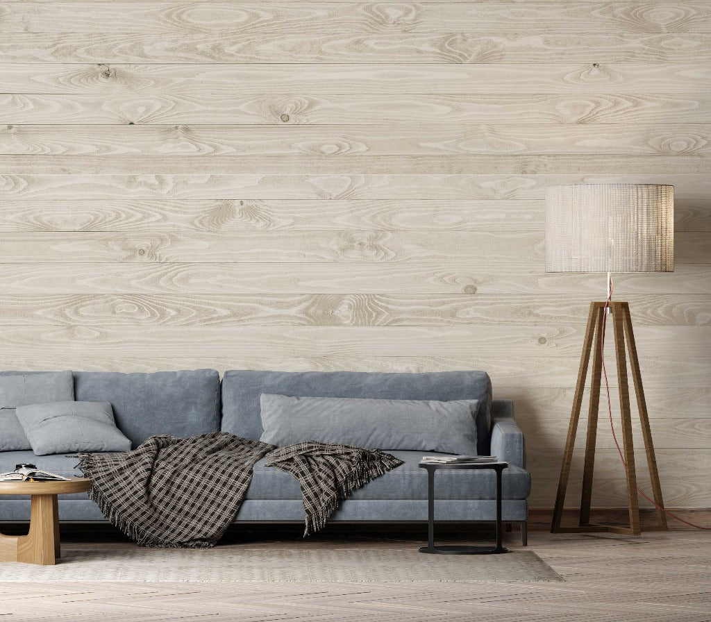 Living Room - A cozy living room corner featuring a gray sofa with a checkered throw blanket, a wooden side table, and a tall floor lamp with a beige shade against Decor2Go White Wood Wallpaper Mural.