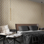 Bedroom - A modern features a large bed with a brown headboard, varied pillows, and a gray throw. Metallic pendant lights enhance the York Wallcoverings White & Gold Harlowe Wallpaper. A cozy lounge chair with footstools completes this stylish space