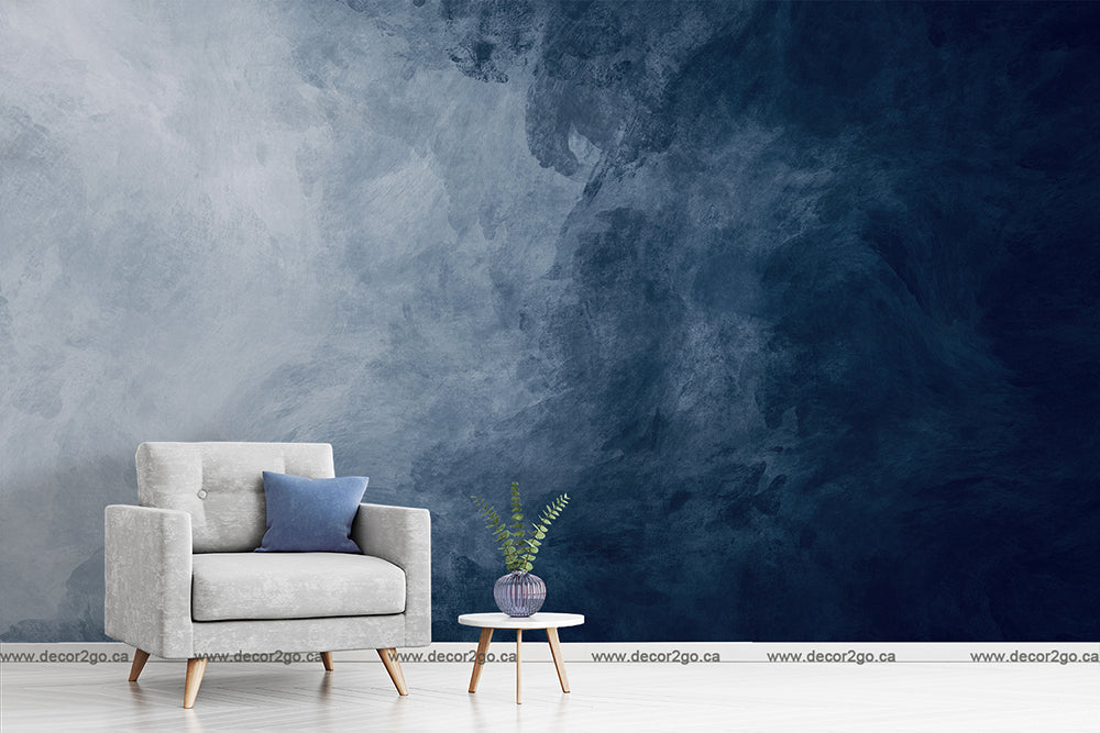 Living Room - A minimalist living room with a grey armchair, a navy blue cushion, a small round table with a plant, against an abstract Decor2Go Wallpaper Mural feature wall.