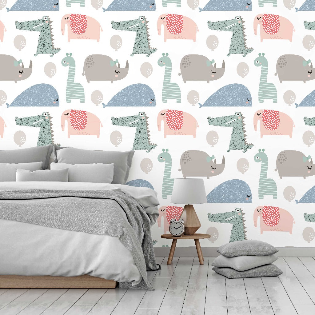 A cozy bedroom featuring a minimalist bed with gray bedding, a small wooden bedside table with a lamp, a clock, and some scattered cushions, set against Decor2Go Wallpaper Mural's Wild Cute Animals Wallpaper Mural with colorful dinosaur patterns.