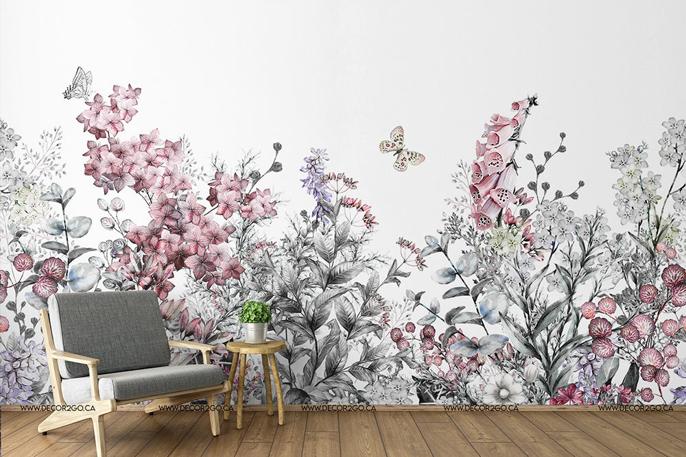 A stylish room with a gray armchair and a small wooden side table against a feature wall showcasing Decor2Go Wallpaper Mural in shades of pink, purple, and gray.