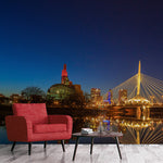 A red armchair and a small table with books are positioned against a backdrop of the Decor2Go Wallpaper Mural Winnipeg Bridge Wallpaper Mural, depicting a romantic atmosphere in a picturesque urban setting.