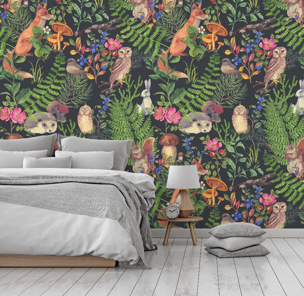 A modern bedroom with a Woodland Wonder Wallpaper Mural custom design featuring colorful illustrations of foxes, owls, and various plants. Neutral bedding and a simple bedside table complement the vibrant walls.