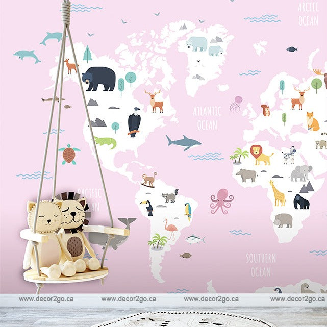 A cozy nursery corner featuring a hanging crib with stuffed animals against a wall adorned with Decor2Go Wallpaper Mural's World Map with Wild Animals Pink Wallpaper Mural that highlights animal habitats across different continents.