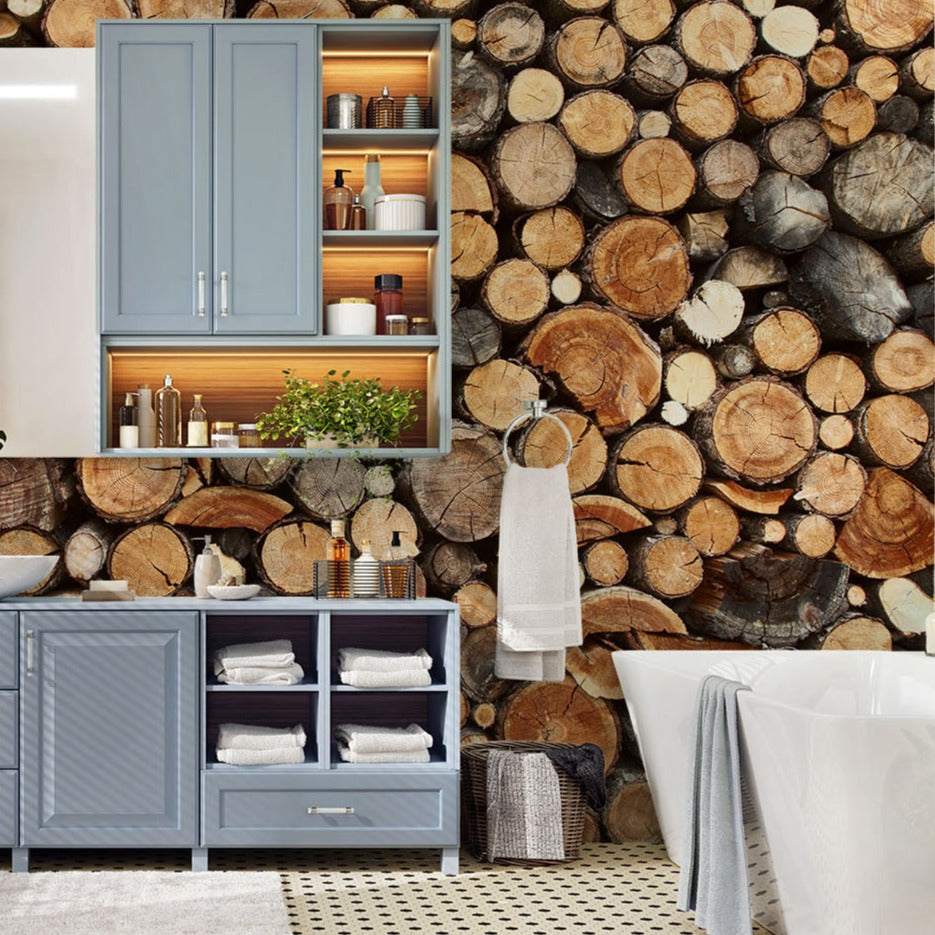 A rustic atmosphere bathroom featuring a feature wall covered in log slices, a blue cabinet with open shelves stocked with towels, and a small mirror above, showcasing the "World of Wood Wallpaper Mural" by Decor2Go Wallpaper Mural, set against a wood-textured background.