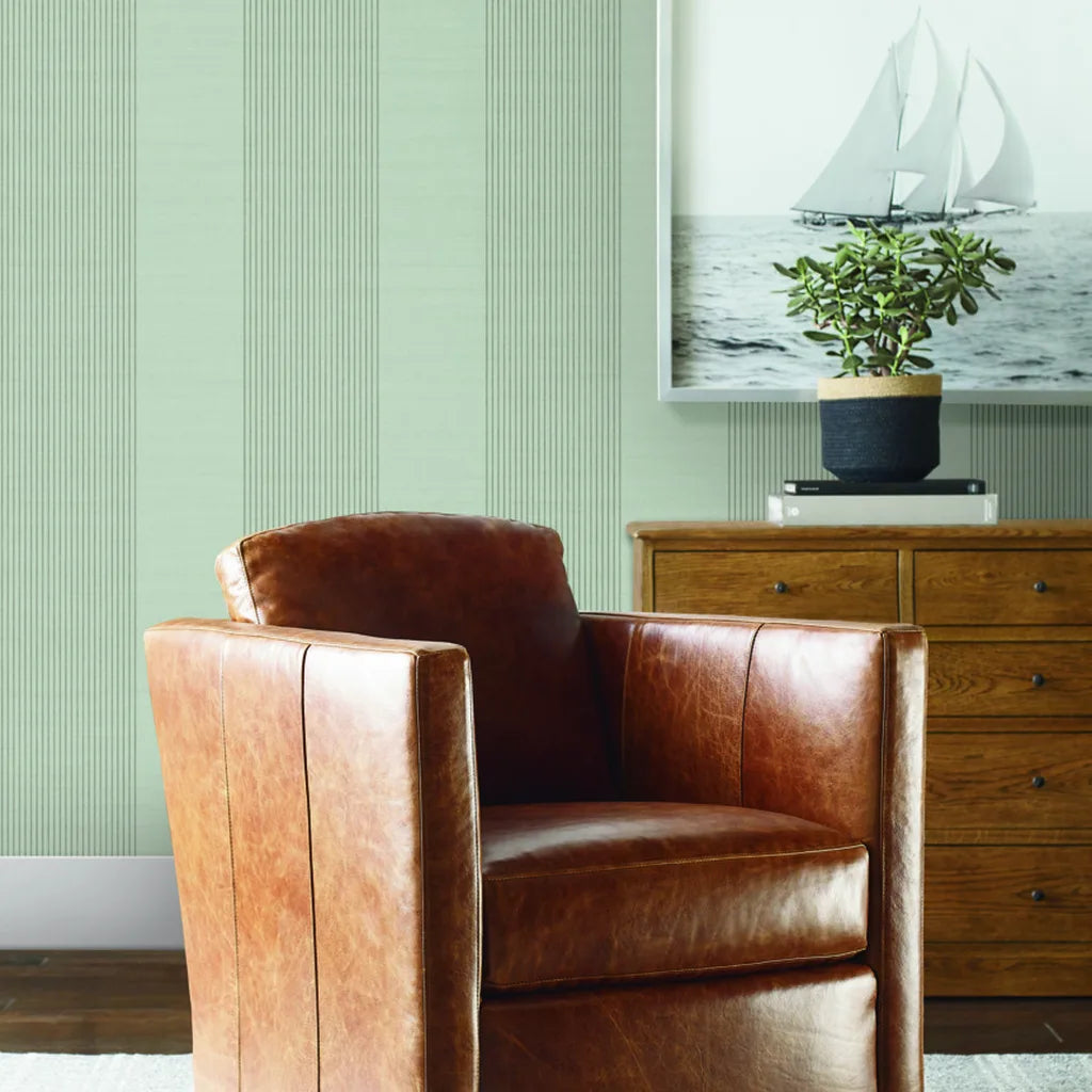 Living room showcasing elegant 'Archer Stripe' wallpaper in Sage Green by York Wallcoverings, creating a serene and stylish space.