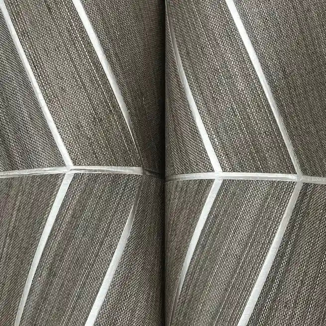 Close-up of York Wallcoverings' Taupe Chevron Abaca wallpaper, showing its natural woven texture and subtle pattern.
