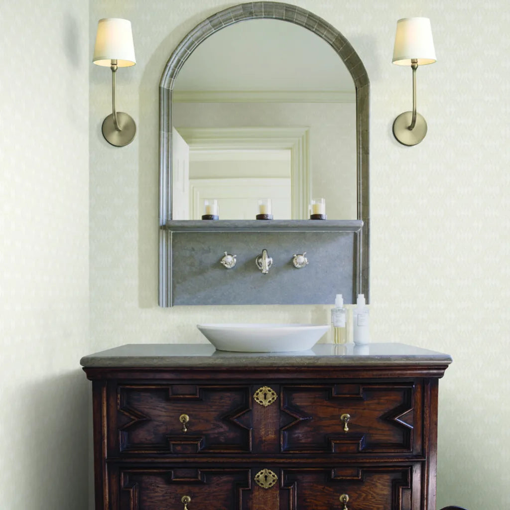 Radcliffe wallpaper in Warm Ivory by York Wallcoverings adds elegant texture to this beautiful bathroom design.