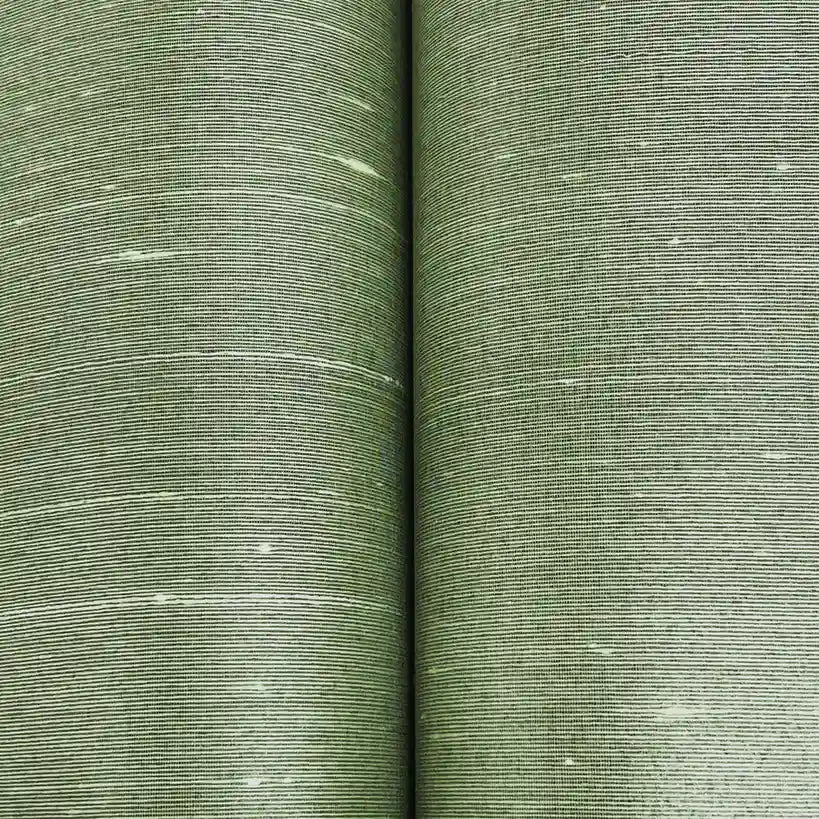 Get a close look at the luxurious woven texture of York Wallcoverings' 'Silk Road' wallpaper in a sophisticated taupe.