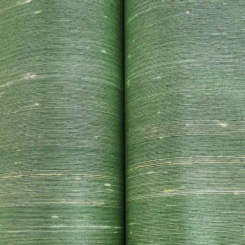 Close-up texture of York Wallcoverings' "Silk Road" wallpaper in calming celadon, highlighting its intricate woven pattern.