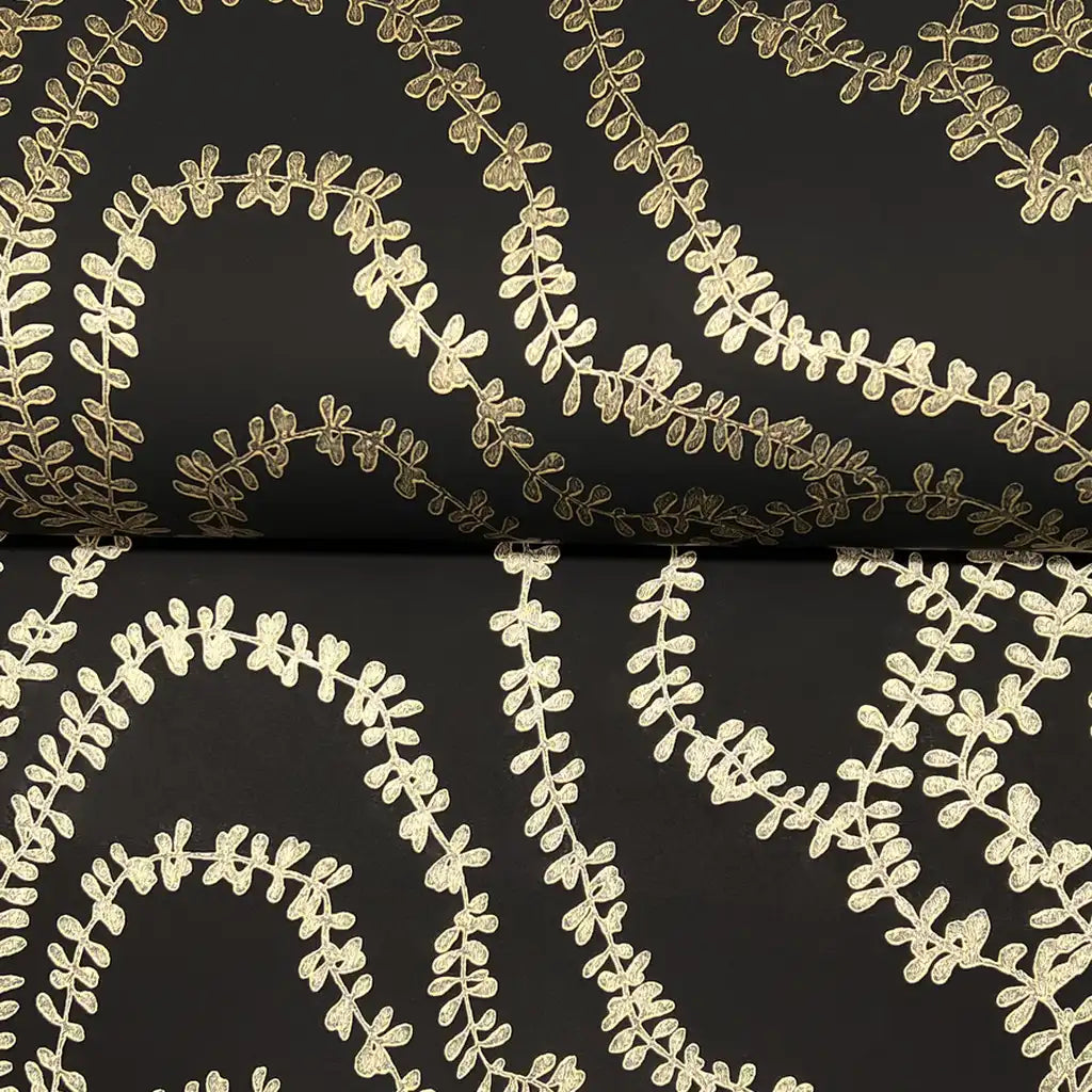 York Wallcoverings' 'String of Pearls' wallpaper close-up, revealing intricate black and gold textured detail.