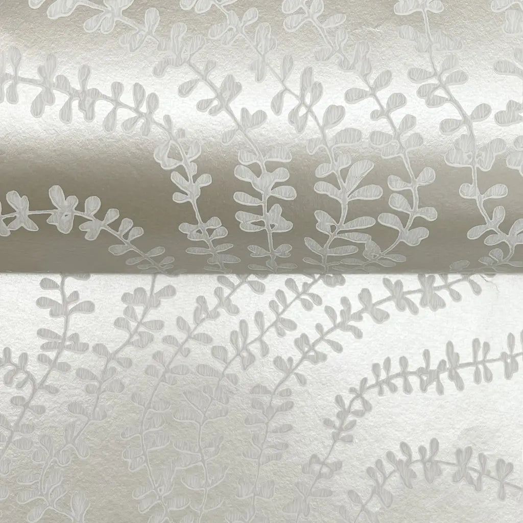 Close-up texture of Warm Ivory 'String of Pearls' wallpaper by York Wallcoverings, highlighting its unique beaded design.