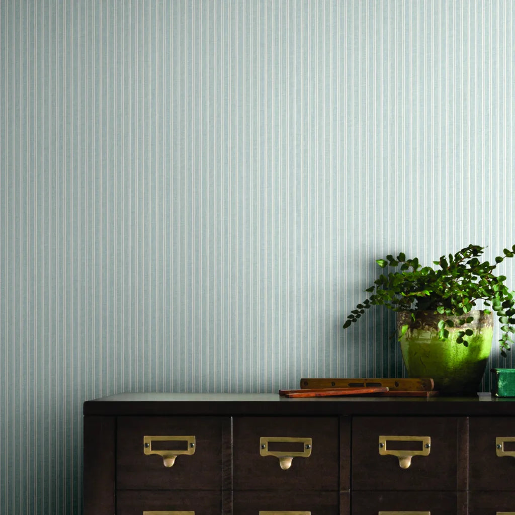 Home office features 'Ticking Stripe' wallpaper in Pale Blue and White by York Wallcoverings, creating a serene workspace.