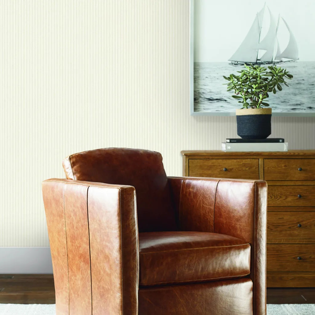 Warm Ivory Ticking Stripe wallpaper by York Wallcoverings adds classic style to a cozy living room.