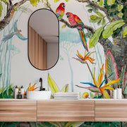Bathroom - A vibrant bathroom with an oval mirror above a wooden vanity. The wall features lush, colorful Escape to the Jungle Wallpaper Mural from Decor2Go Wallpaper Mural of a watercolor forest with parrots, hummingbirds, and exotic flowers.
