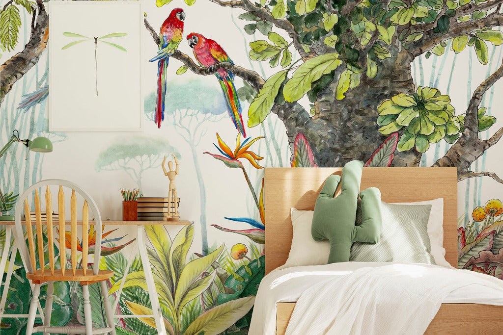 Bedroom - A vibrant bedroom with Decor2Go Wallpaper Mural's Escape to the Jungle Wallpaper Mural depicting a watercolor forest and colorful birds. A wooden chair and desk sit beside a bed with white linens and green pillows.