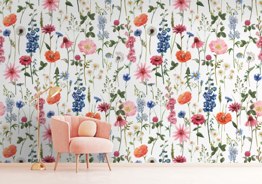 A stylish interior featuring a peach-colored armchair with a round cushion against Decor2Go Wallpaper Mural's Floral Summer Wallpaper Mural with a rich array of colorful blooms. A golden floor lamp sits to the left of the chair, enhancing its
