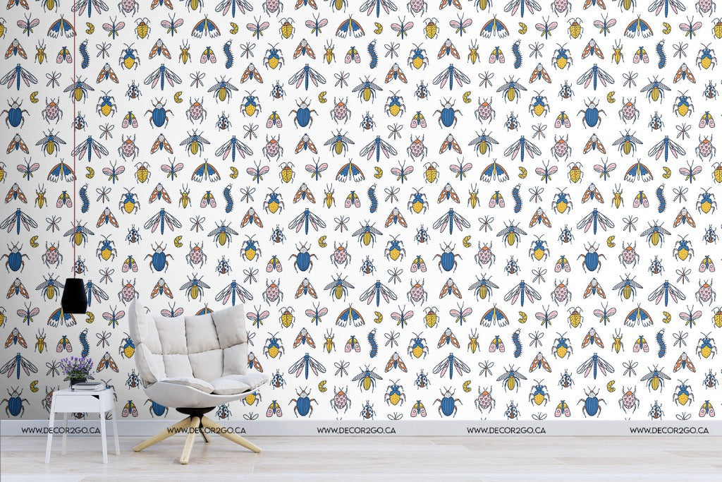 A room featuring a feature wall covered in Decor2Go Wallpaper Mural's vibrant, Scandinavian-style floral The Beetles Wallpaper Mural, a white armchair, and a small black lamp on a white side table in the foreground.