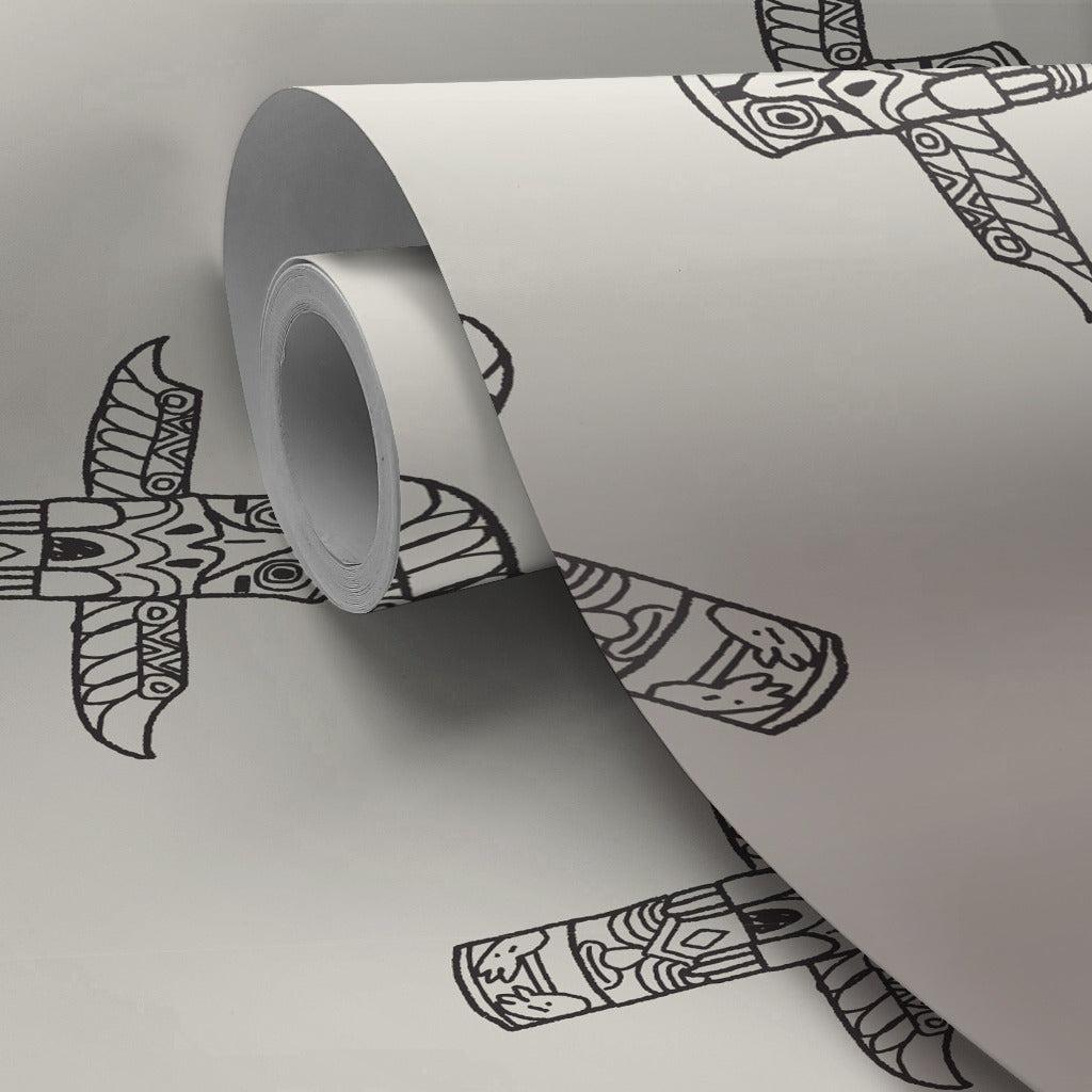 A roll of tape with a decorative pattern featuring Decor2Go Wallpaper Mural unrolling on a smooth gray surface. The tape displays intricate black and white patterns resembling totemic symbols.