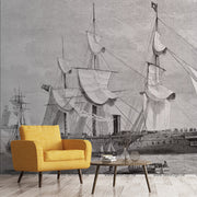 Living Room - A modern living room with a bright orange armchair and a small wood table, in front of a large black and white mural of Decor2Go Wallpaper Mural sailing ships, inspired by classic pirate stories.