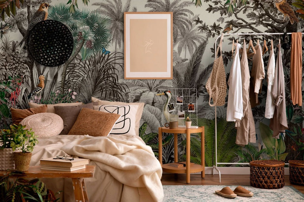 Bedroom - A cozy bedroom corner with a Vintage Jungle Wallpaper Mural by Decor2Go Wallpaper Mural featuring birds and dense foliage, a neatly made bed, a small wooden stool, hanging clothes, and various plants enhancing the room’s natural vibe.