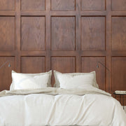 Bedroom - A modern bedroom featuring a large bed with white bedding in front of a tall Decor2Go Wallpaper Mural adorned with a Wood Panels III Wallpaper Mural. A small, round side table is placed next to the bed.