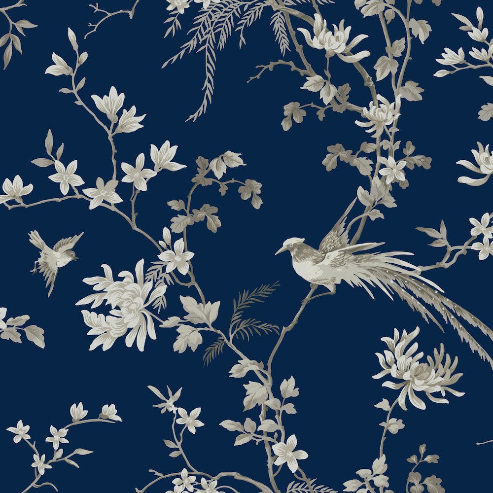 Bird and Blossom Chinoiserie Wallpaper (60 SqFt) by York Wallcoverings featuring beige and gray illustrations of birds perched on delicate branches with blooming flowers against a dark blue background. The intricate Asian botanical pattern includes various leaves and blossoms, exuding a classic and elegant style.